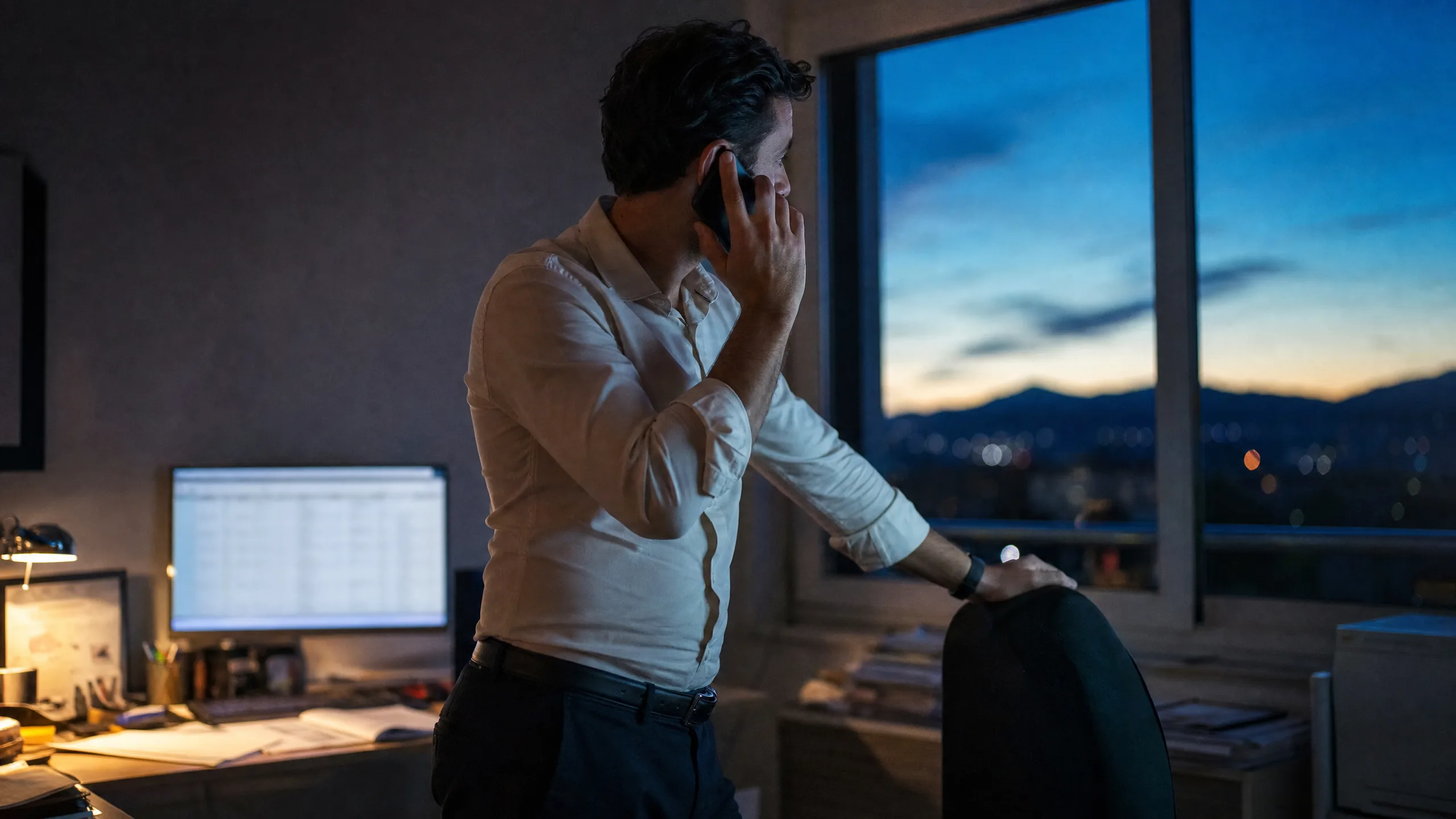 Un gérant au téléphone dans son bureau au lever du jour