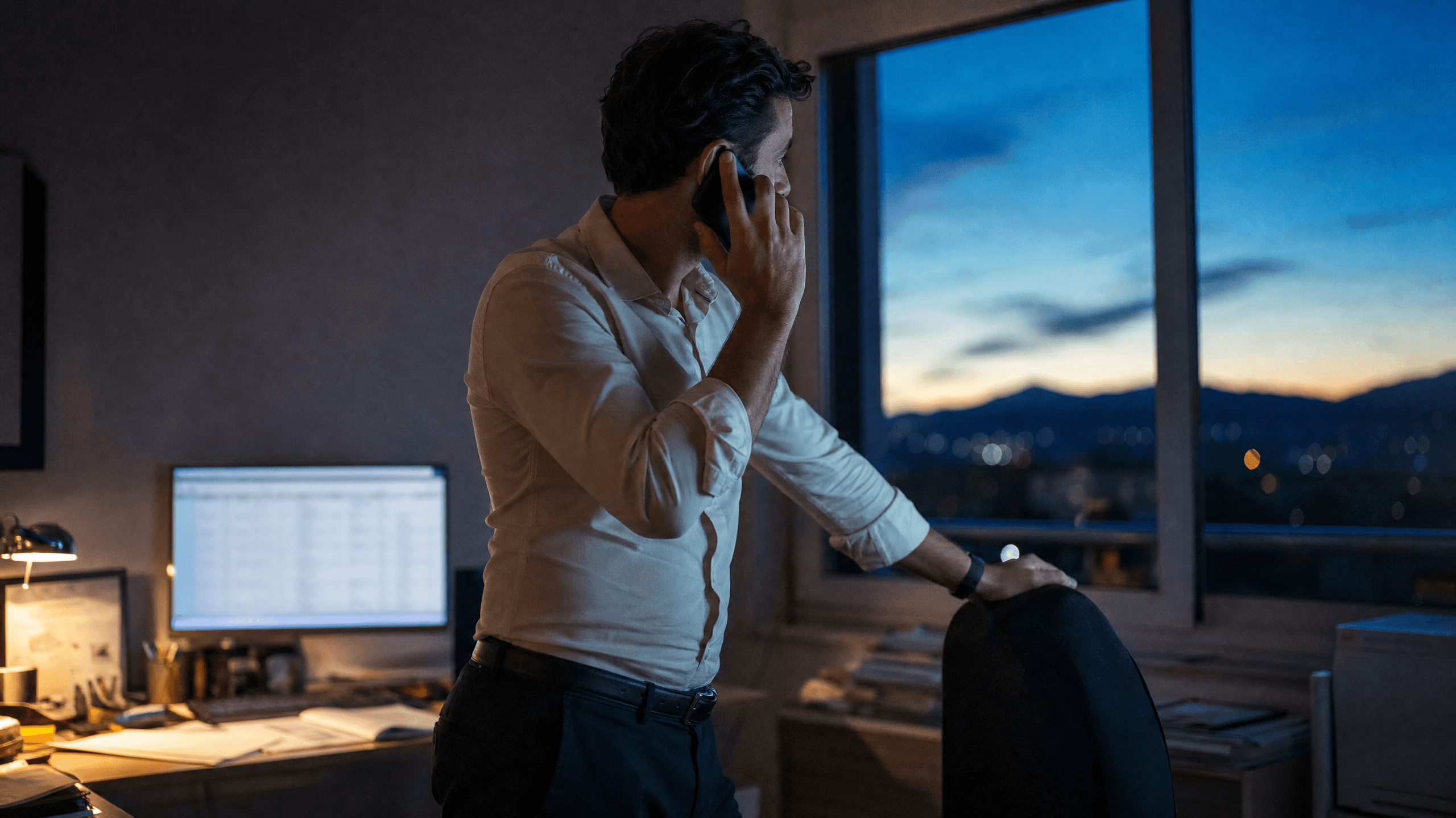 Un gérant au téléphone dans son bureau au lever du jour